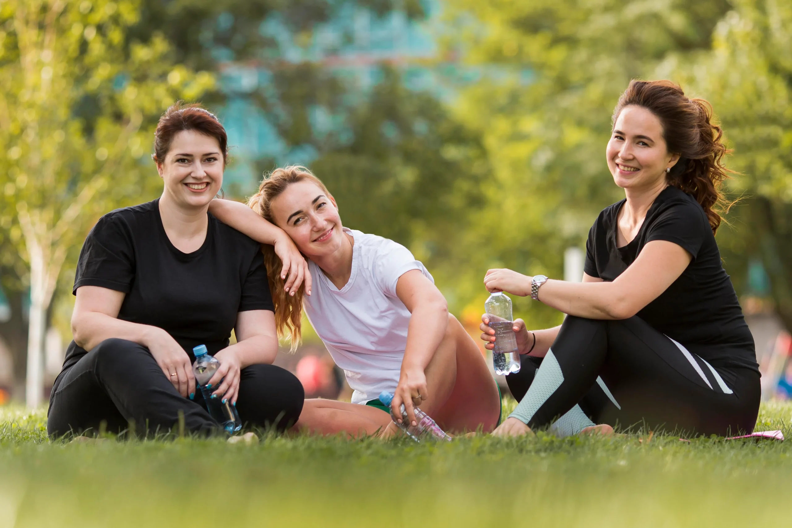 front-view-best-friends-sitting-grass-while-wearing-sportswear
